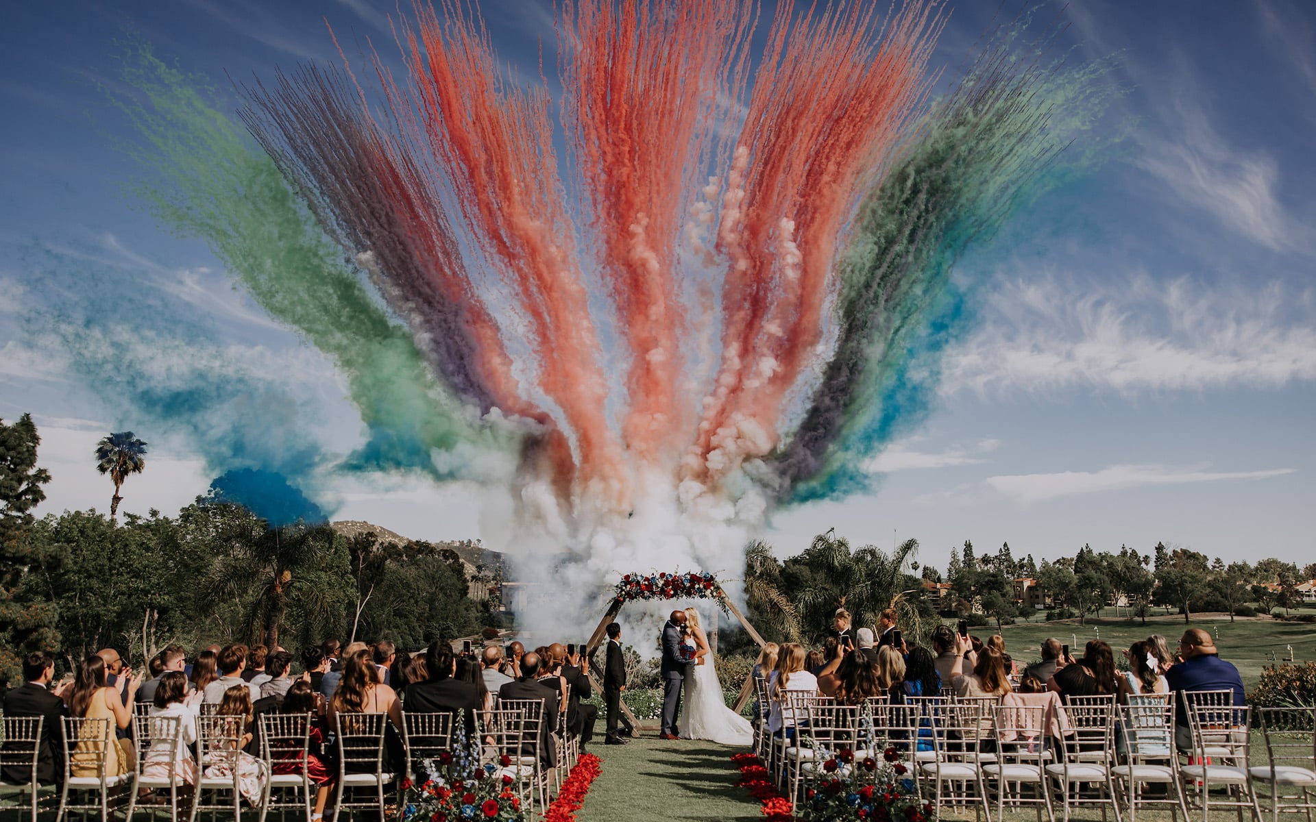 Multicolored smoke in background of a wedding ceremony on a golf course